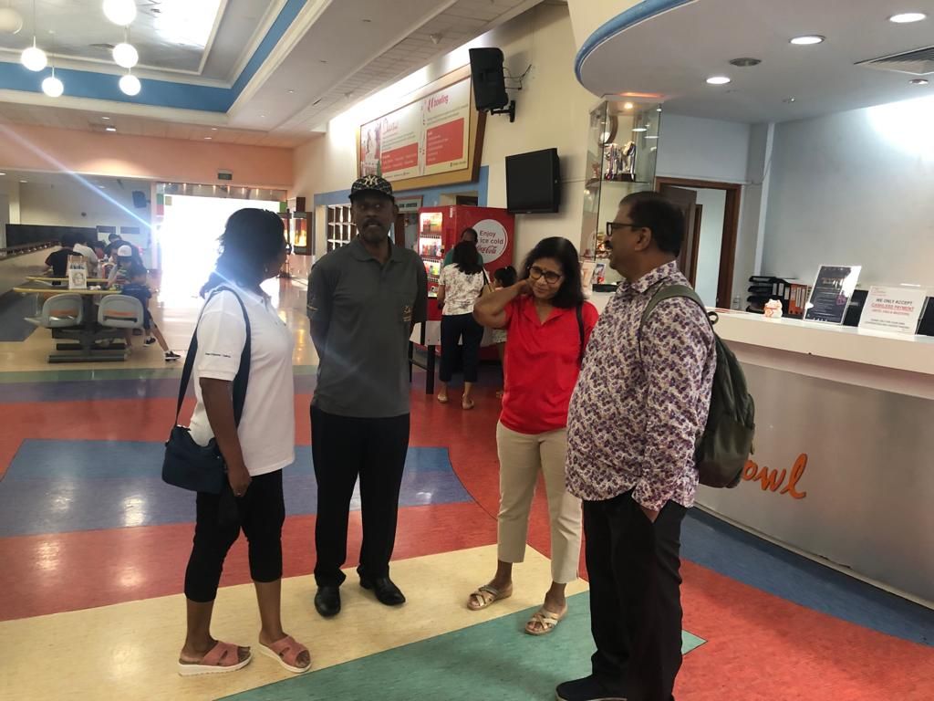 Members chatting together inside the Orchid Country Club bowling alley