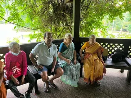 Senior members seated together in a garden pavilion